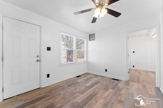 interior space with visible vents, baseboards, and wood finished floors