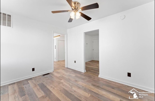 unfurnished bedroom featuring light wood-style floors, baseboards, visible vents, and ceiling fan