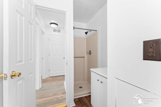 bathroom featuring a stall shower, wood finished floors, and visible vents