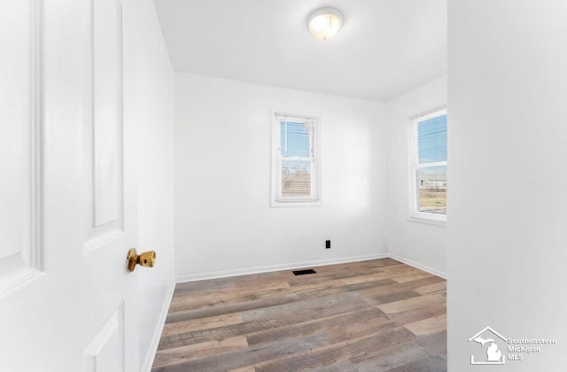 interior space with wood finished floors, visible vents, and baseboards