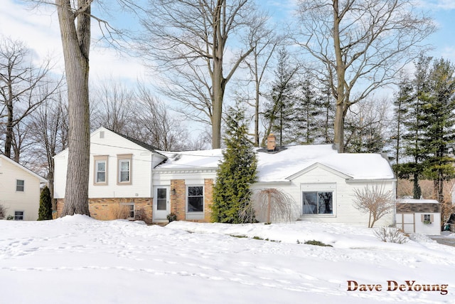 view of front of house with brick siding and a chimney