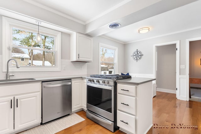 kitchen with visible vents, appliances with stainless steel finishes, white cabinetry, a sink, and a peninsula