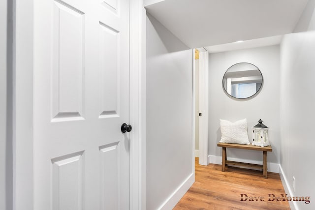 hall with light wood-style floors and baseboards