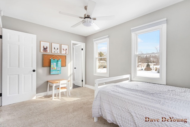 bedroom featuring a ceiling fan, light colored carpet, and baseboards