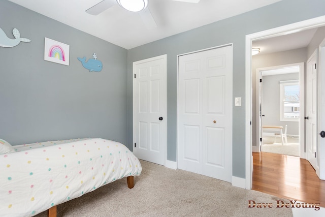 carpeted bedroom with ceiling fan, a closet, and baseboards