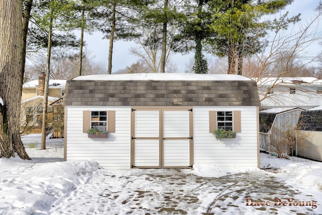 snow covered structure featuring an outdoor structure