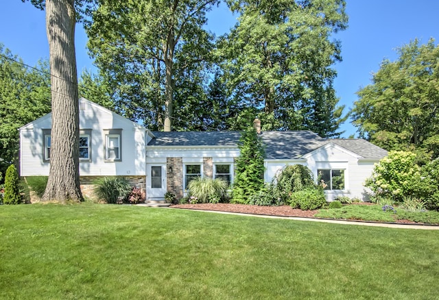 tri-level home with a chimney and a front lawn