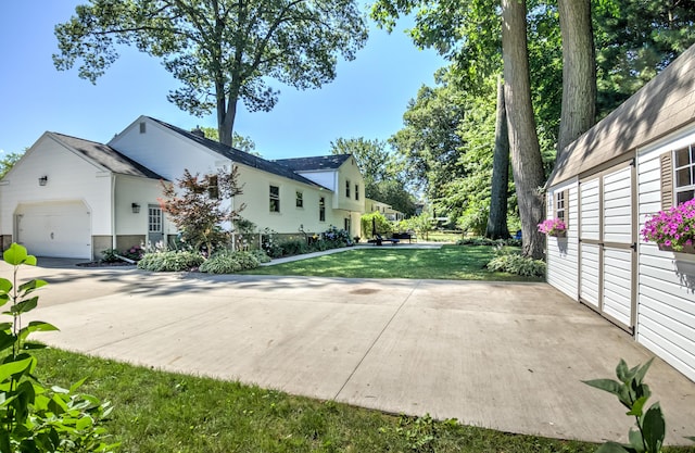 view of side of property with a garage, concrete driveway, and a yard