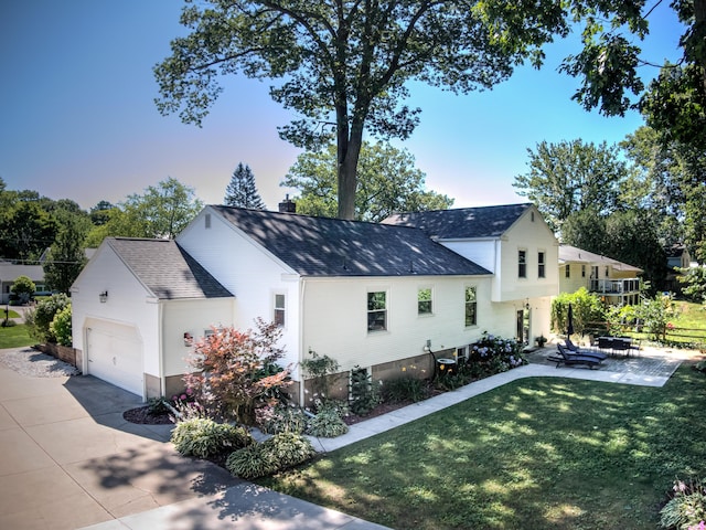 view of front of property featuring an attached garage, concrete driveway, roof with shingles, a chimney, and a front yard