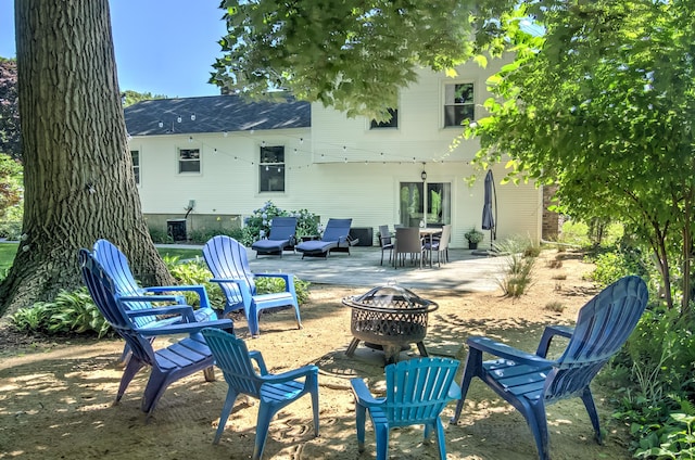 back of property with a patio and an outdoor fire pit