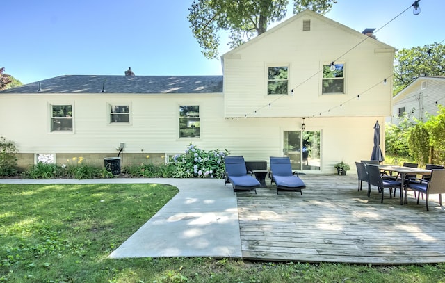 back of property featuring cooling unit, a yard, a chimney, and a wooden deck