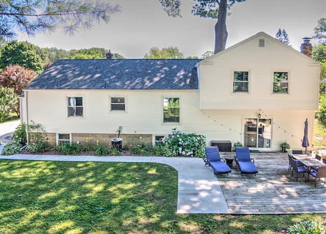 rear view of house featuring a shingled roof, a lawn, a chimney, a wooden deck, and central air condition unit