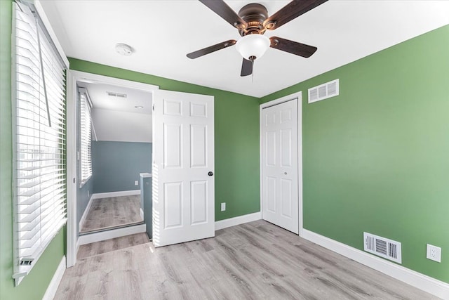 unfurnished bedroom with light wood-style floors, a closet, visible vents, and baseboards