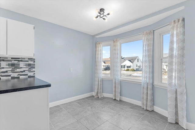 unfurnished dining area with baseboards