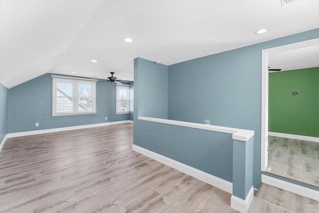 spare room with recessed lighting, light wood-style floors, vaulted ceiling, ceiling fan, and baseboards