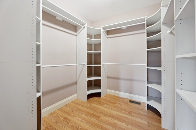 spacious closet featuring wood finished floors and visible vents