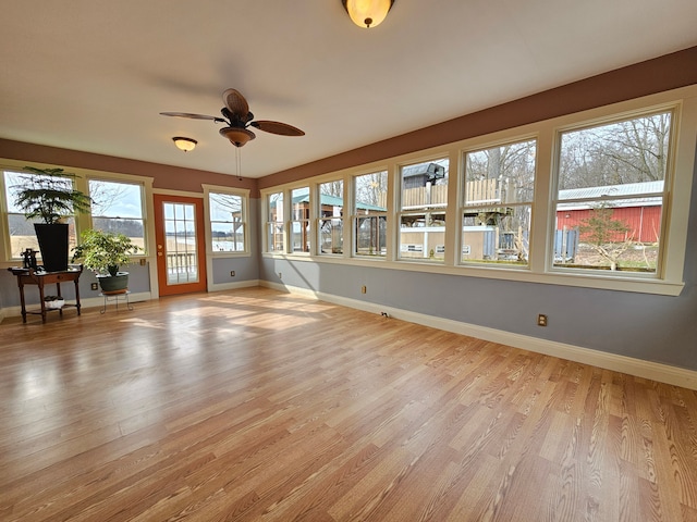 unfurnished sunroom with a ceiling fan