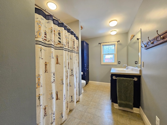 full bath with toilet, baseboards, and vanity