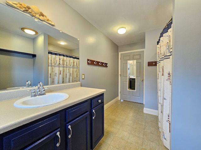 bathroom with tile patterned floors, baseboards, and vanity