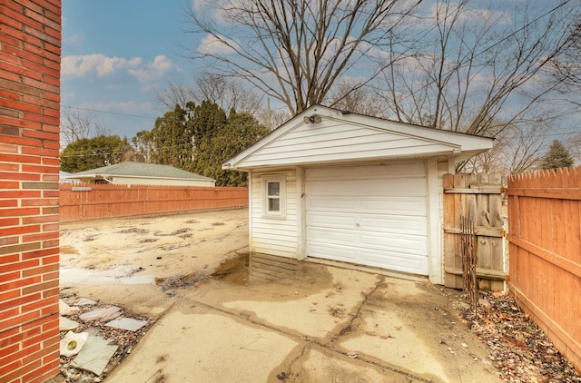 detached garage with driveway and fence