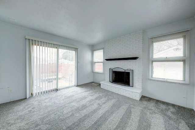 unfurnished living room featuring carpet flooring and a fireplace