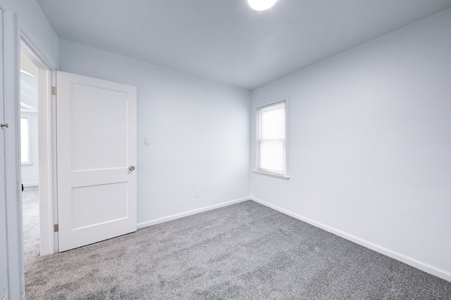 carpeted spare room with baseboards