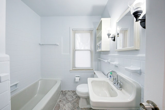 bathroom featuring toilet, a sink, and tile walls