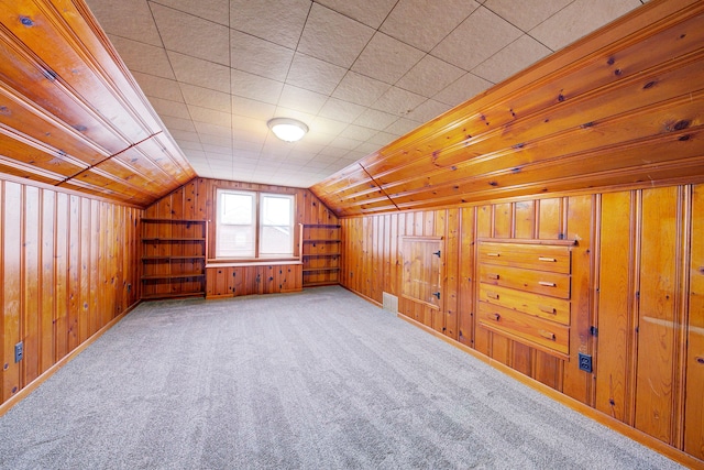 bonus room featuring lofted ceiling, wooden walls, and carpet flooring