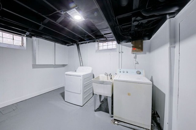 laundry room featuring separate washer and dryer, a sink, a wealth of natural light, and baseboards