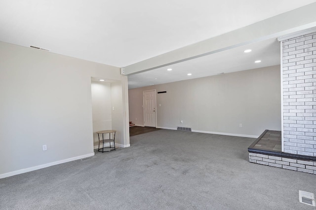 unfurnished living room with carpet floors, visible vents, and baseboards