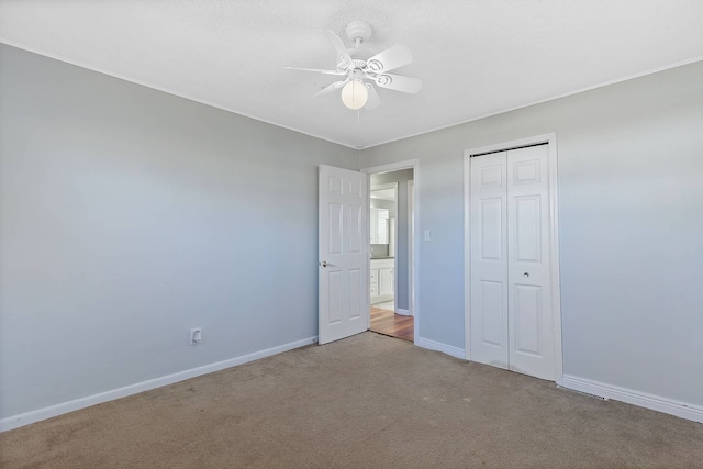 unfurnished bedroom featuring carpet floors, a closet, ceiling fan, and baseboards