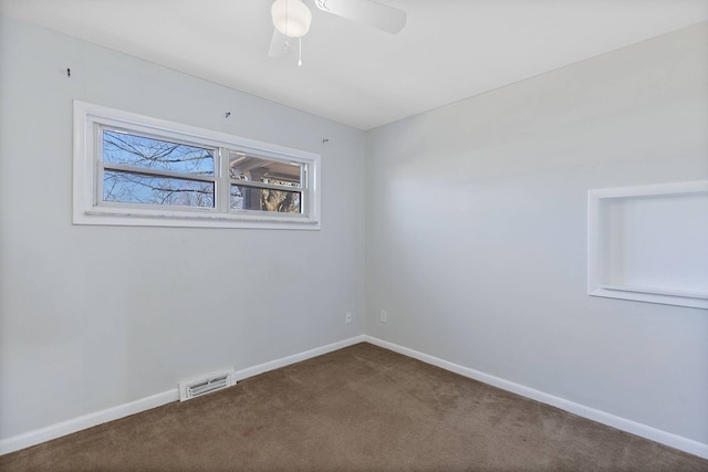 carpeted empty room with ceiling fan, visible vents, and baseboards