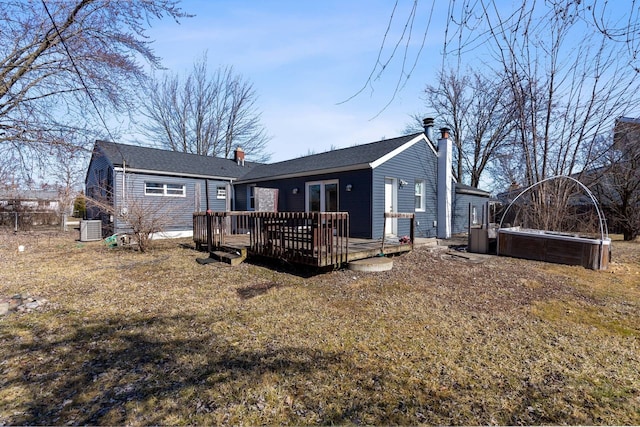 rear view of house featuring a jacuzzi, a chimney, central AC unit, and a deck