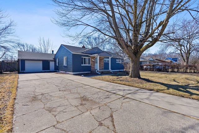 ranch-style home with a chimney, an attached garage, fence, driveway, and a front lawn