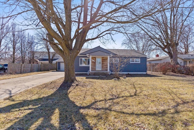 ranch-style home with a front yard and fence