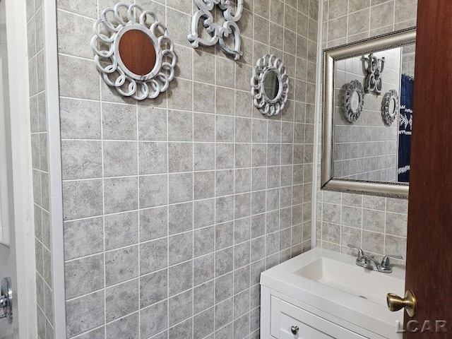 bathroom with tile walls, vanity, and decorative backsplash