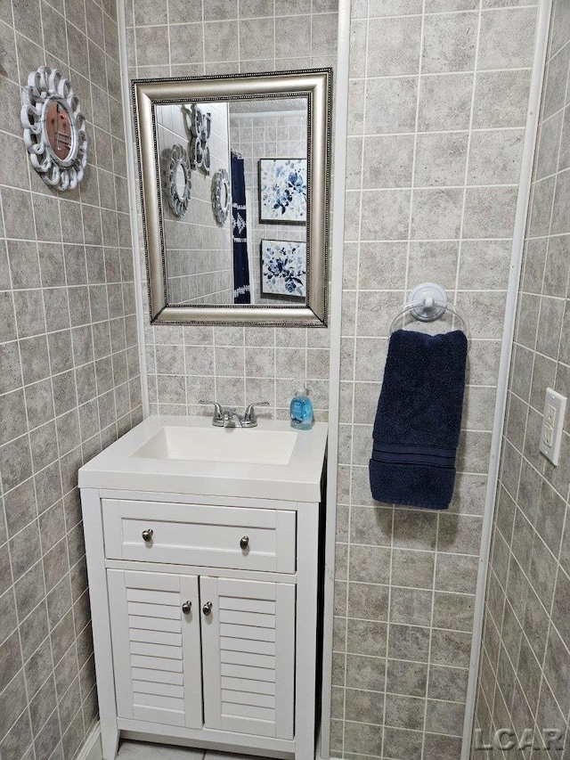 bathroom featuring vanity and tile walls