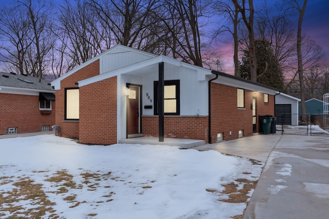 view of front of property featuring an outbuilding, brick siding, and a garage