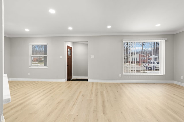 empty room featuring recessed lighting, a healthy amount of sunlight, light wood-style flooring, and baseboards