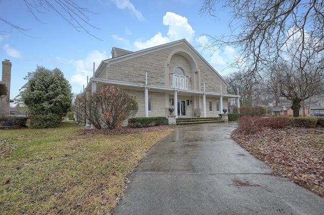 view of front of house with stone siding and a front yard