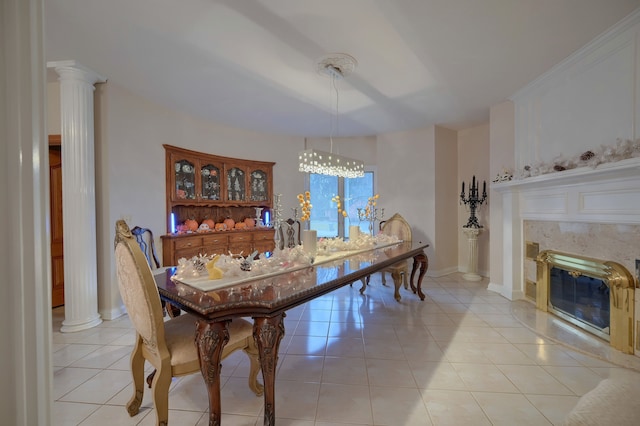 dining space featuring a fireplace, decorative columns, baseboards, and light tile patterned flooring