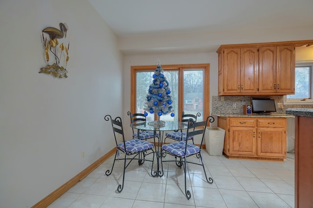 dining room with light tile patterned floors and baseboards