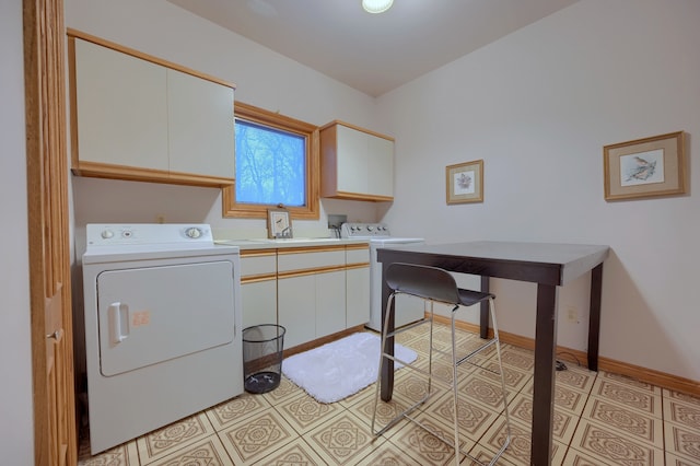 laundry area featuring baseboards, cabinet space, separate washer and dryer, and light tile patterned flooring