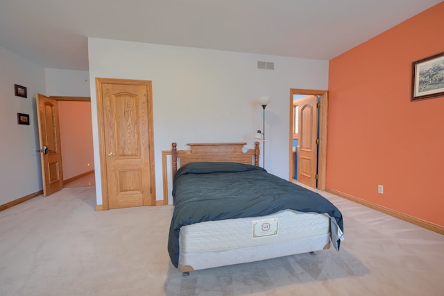 bedroom with baseboards, visible vents, and light colored carpet