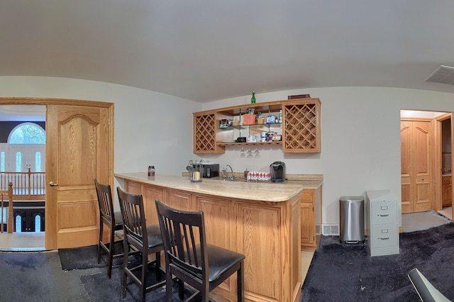 bar featuring wet bar, visible vents, and dark carpet