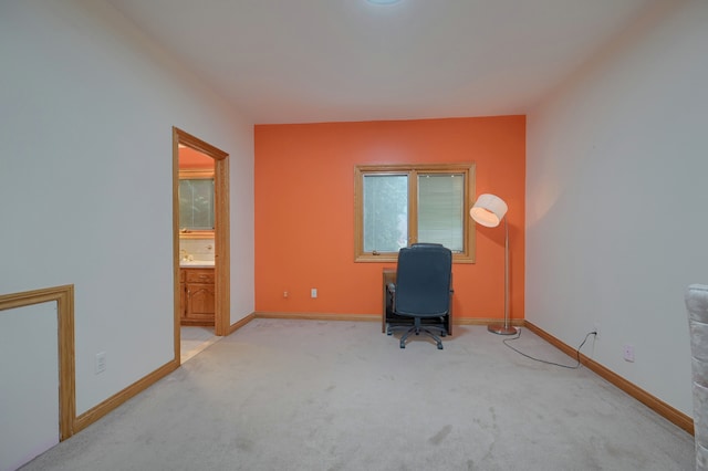 unfurnished office featuring light colored carpet and baseboards