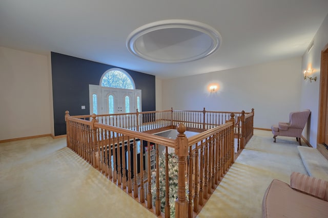 hallway featuring baseboards and light colored carpet