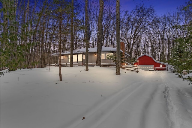 view of front of property with an outdoor structure, a detached garage, and a barn