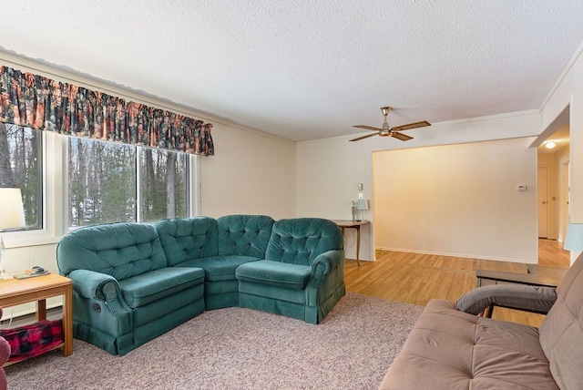 living area with a textured ceiling, ceiling fan, wood finished floors, and crown molding