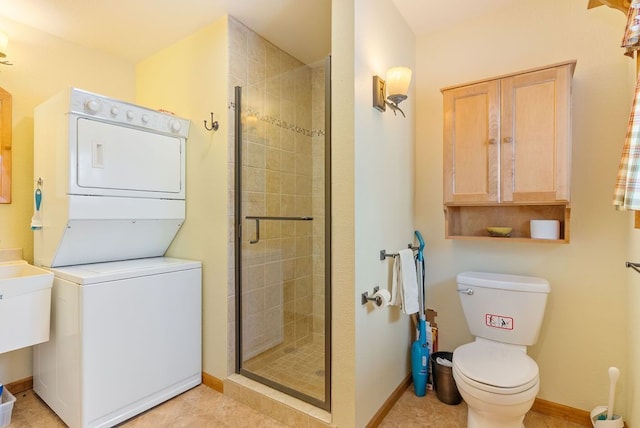 full bathroom featuring stacked washer and dryer, baseboards, a shower stall, and toilet